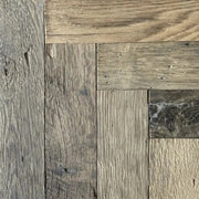 Reclaimed oak herringbone flooring with aged surface in an interior
