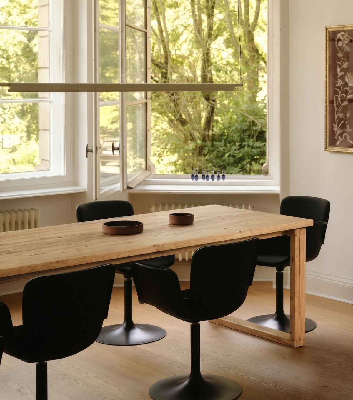 Doque Reclaimed Oak Dining Table – with black chairs beside open windows