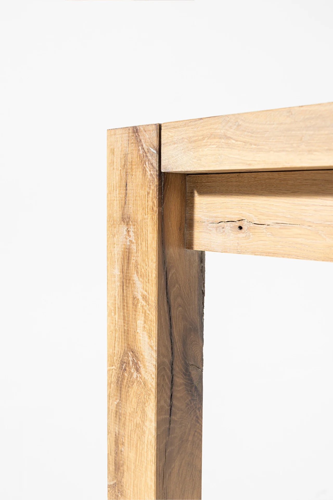 Driftwood dining table block leg and frame connection showing natural knot and weathered oak character