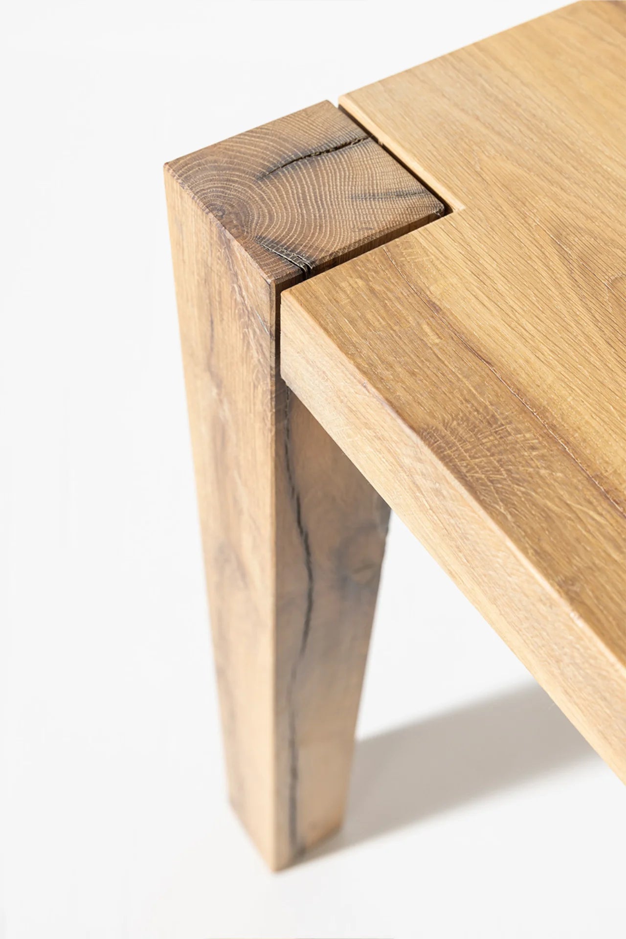 Driftwood reclaimed wood dining table front view showing block corner legs and open underside design