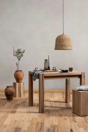 Driftwood reclaimed wood dining table in a styled room setting with woven pendant light and terracotta accessories