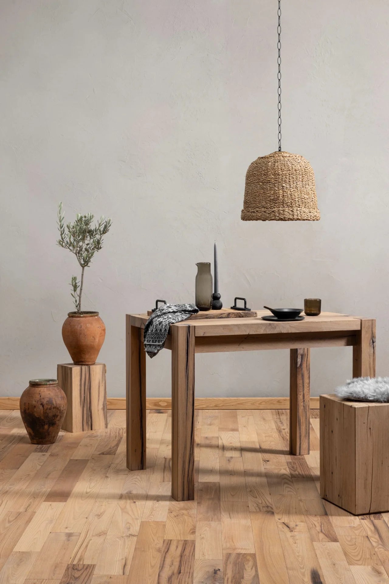 Driftwood reclaimed wood dining table in a styled room setting with woven pendant light and terracotta accessories