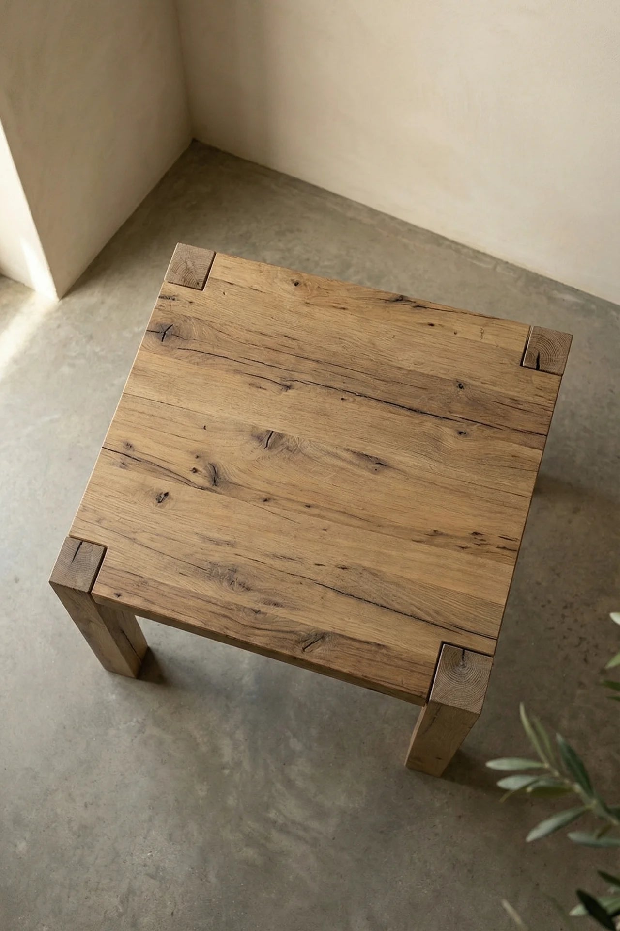 Driftwood reclaimed wood dining table corner detail in styled setting with Mediterranean ceramics and woven pendant