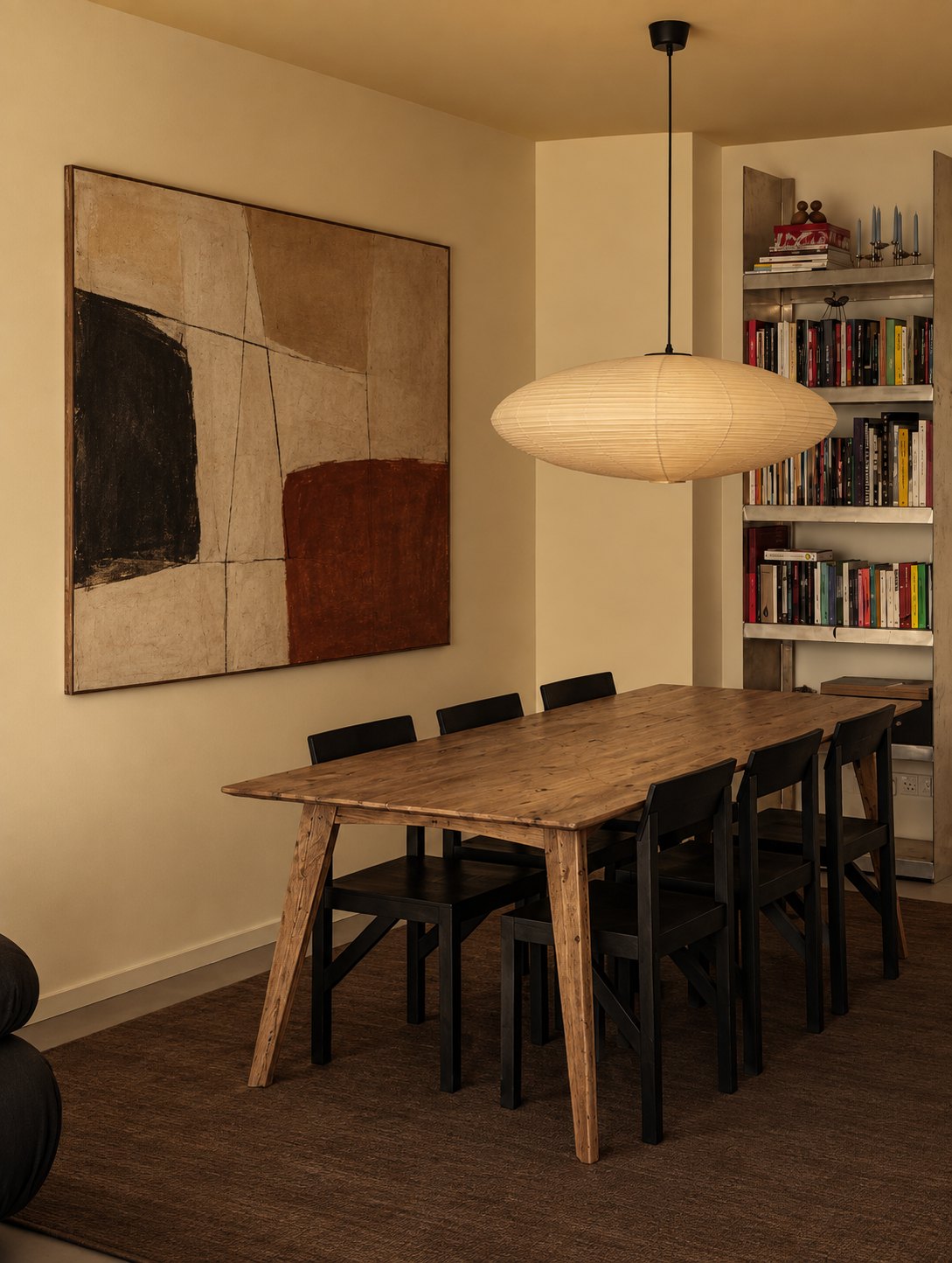 Mariner Reclaimed Oak Dining Table – in a dining room with black chairs and bookshelves