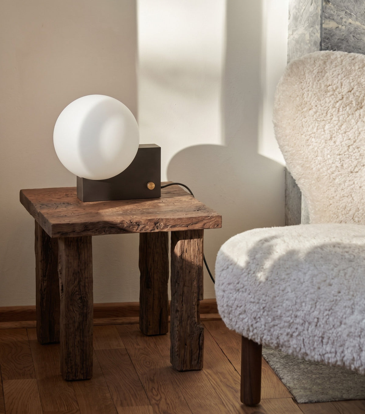 Ostia Reclaimed Oak Side Table – with a globe lamp beside a sheepskin chair