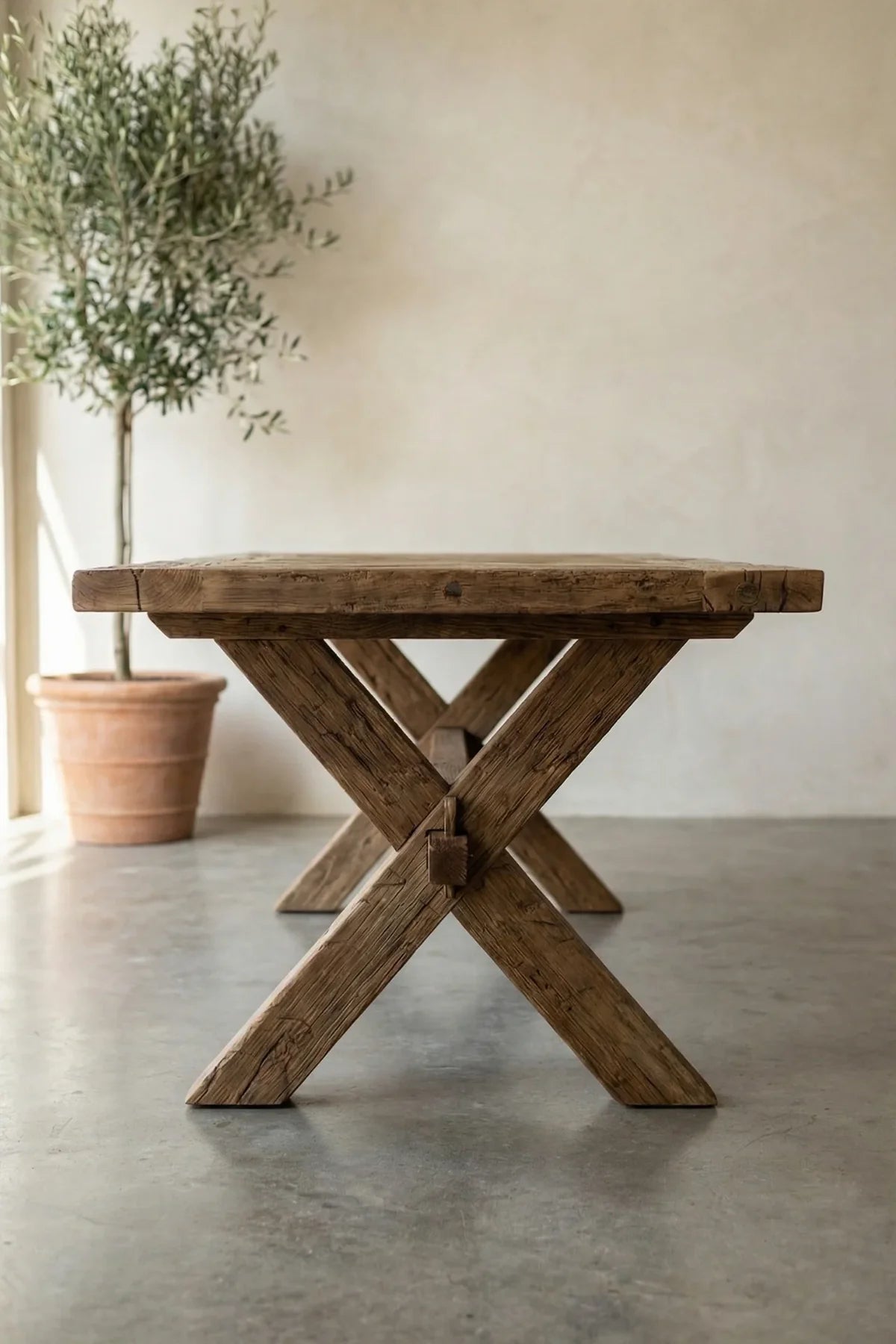 Petra reclaimed oak dining table — three-quarter angle view showing herringbone surface and structural beam legs