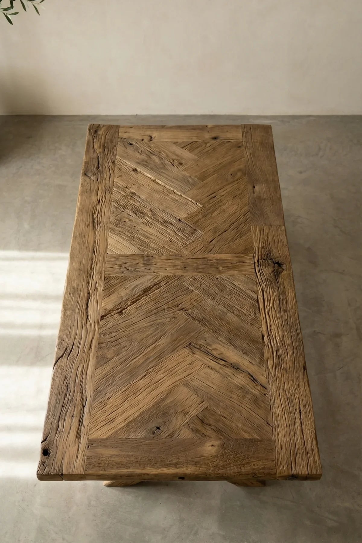 Top-down view of the Petra herringbone dining table surface — reclaimed oak plank arrangement