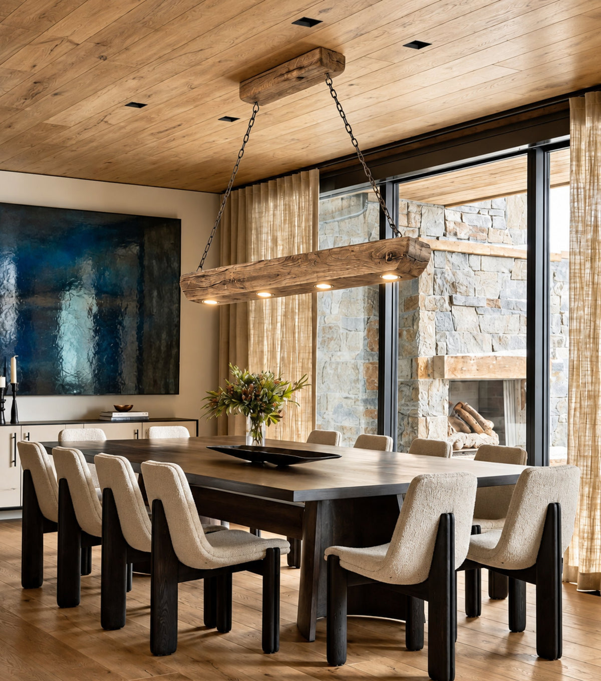 Tegmen Reclaimed Chestnut Beam Pendant Light – above a dark dining table with upholstered chairs