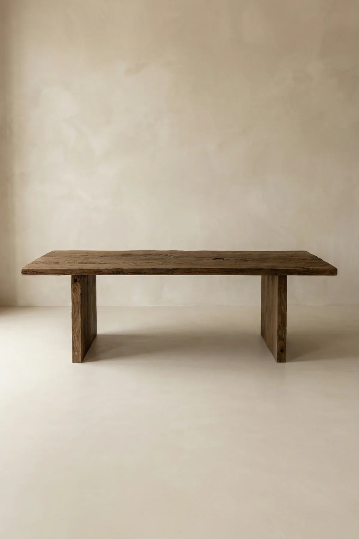 Thebes dining table — front view showing lightly brushed reclaimed oak surface and structural beam legs
