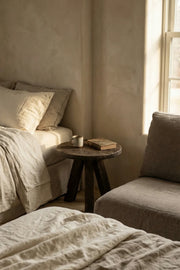 Tifa reclaimed oak side table styled beside a chair in a contemporary interior