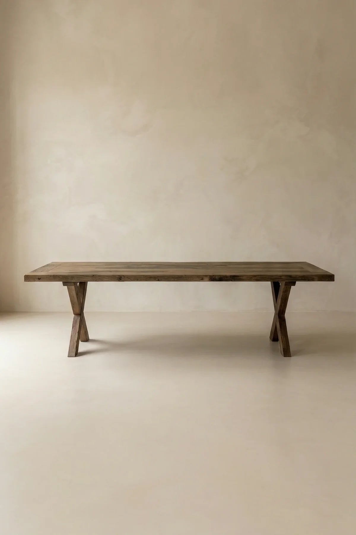 Side profile of the Traverse dining table showing the full crossed leg form and apron construction